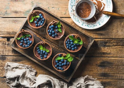 Dutch process cocoa tends to taste milder, while natural cocoa powder can have a sharper flavor. Photos - Homemade Tiramisu dessert and sieve with cocoa powder in tray - YouWorkForThem