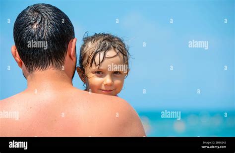 Daddy At The Beach Wrapping His Little Girl In A Towel After Bath On
