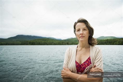 Mature Woman In Open Countryside Standing With Arms Folded By Mountain Lake New York Beauty