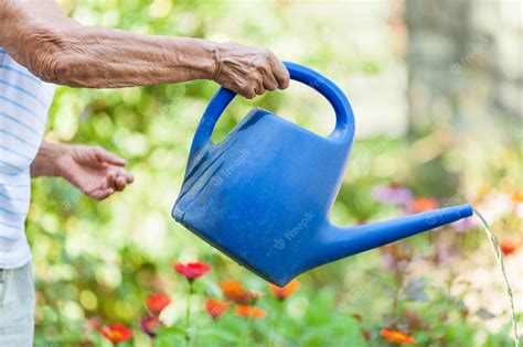 Premium Photo Elderly Woman Watering Plants In Her Garden