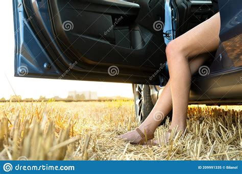 Piernas Desnudas De Una Mujer Chofer Parada Cerca Del Auto En El Campo De Verano Imagen De