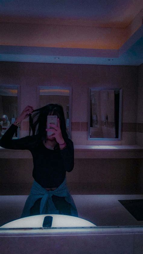 Download A Woman Is Taking A Selfie In A Bathroom Mirror