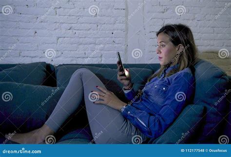 Young Attractive 20s Woman Lying On Home Sofa Couch Using Internet On