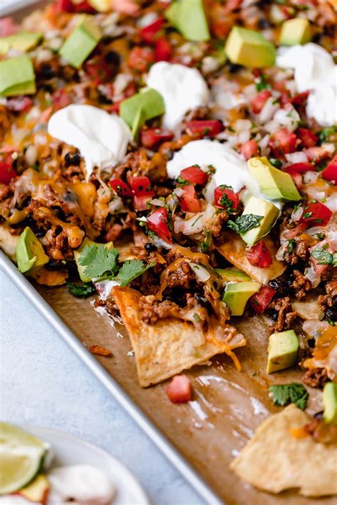 Easy Nachos Layered With Seasoned Beef And Black Beans Melty Cheese Avocado And Sour Cream