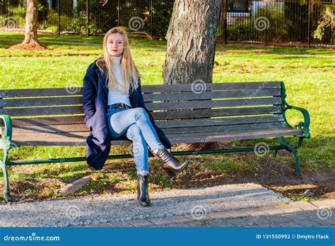 Beautiful Woman Sitting On Bench In Sunny Autumn Day In The Park Stock