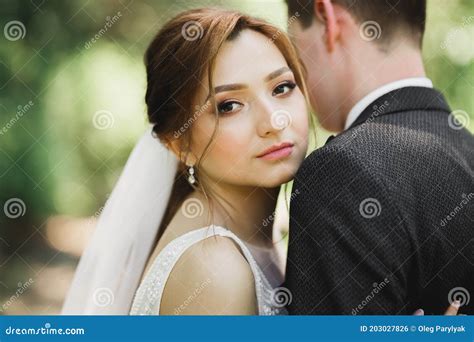 Beautiful Romantic Wedding Couple Of Newlyweds Hugging In Park Stock