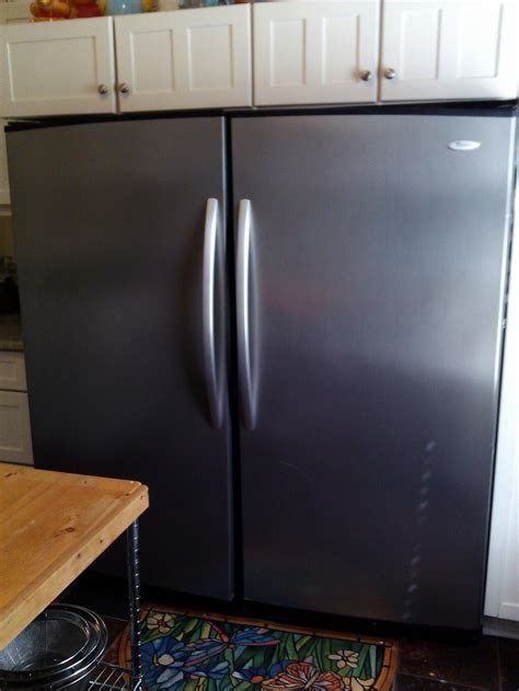 A Black Refrigerator Freezer Sitting Inside Of A Kitchen