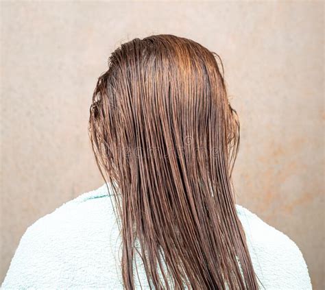 Woman Sits With Her Back To The Camera With Her Wet Hair Combed Stock