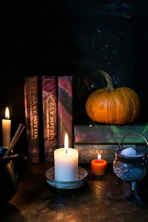 Candles And Books On A Table In Front Of A Pumpkin