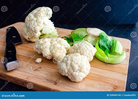 Chopping Cauliflower Into Florets On A Bamboo Cutting Board Stock Image