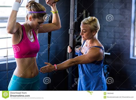 Female Trainer Instructing Woman In Gym Stock Photo Image Of