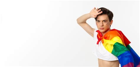 premium photo beautiful gay man with glitter on face wearing crop top and rainbow lgbt flag