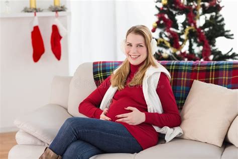 Beautiful Pregnant Woman Holding Her Belly Sitting On Couch Stock Image