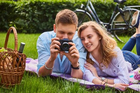 Любящая молодая пара фотографируется и отдыхает на пикнике в парке