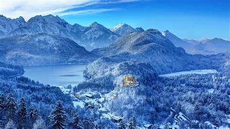 Beautiful Landscape View Of Snow Covered Mountains And Trees In Blue