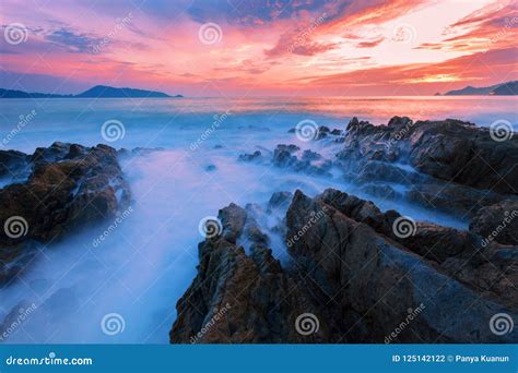 Long Exposure Image Of Dramatic Sky And Wave Seascape With Rock Stock