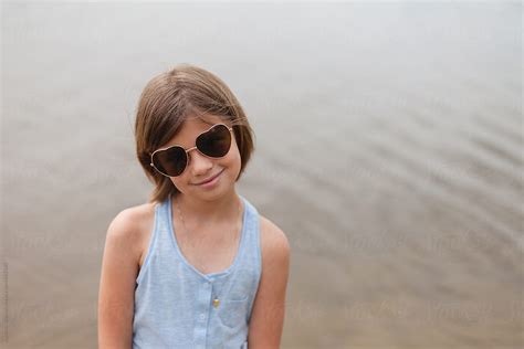 stylish 8 year old wearing heart shaped aviator sunglasses smiling at the camera del