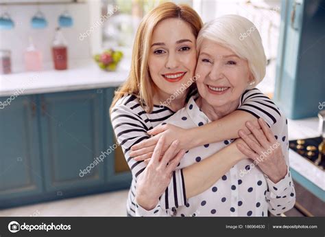 Mujer Feliz Abrazando A Su Madre Mayor En La Cocina Fotografía De