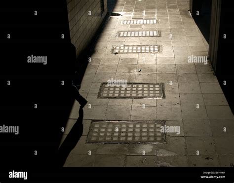 Man stepping into shadows from sunlight alleyway Stock Photo - Alamy