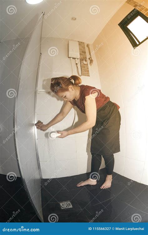 Asian Maid Or Housekeeper Cleaning Spray Water In Toilet Stock Image