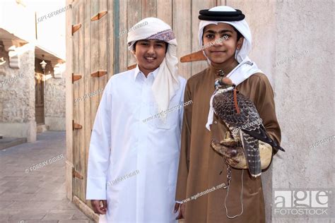 Qatari Children In Traditional Dress Proudly Posing With Their Falcon