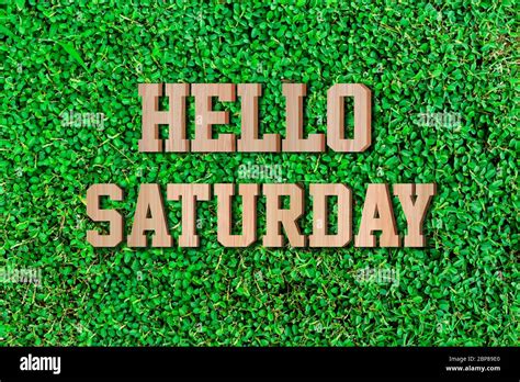 Hello Saturday Made From Wooden Alphabet On Green Leaf Background Stock