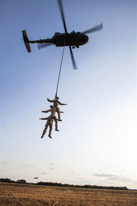 Airmen Are Lifted Up By A Uh 60 Black Hawk Helicopter To A Fast Rope Insertion And Extraction