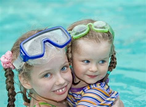 Children Swim Underwater In Swimming Pool Happy Active Girls Have Fun