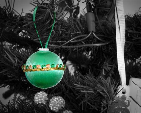 A Green Ornament Hanging From A Christmas Tree In Black And White With