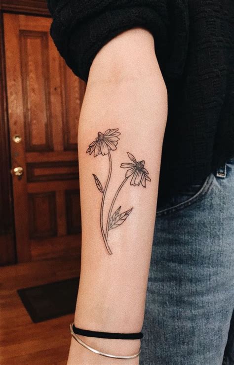 A Womans Arm With A Flower Tattoo On The Left Side Of Her Arm