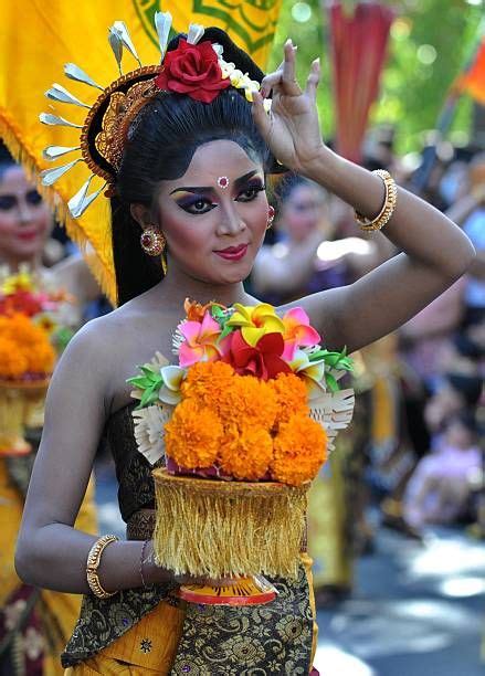 A Balinese Woman In Traditional Dress Participates In A Parade For