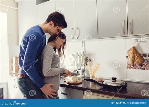 Young Couple On Kitchen Hugging And Cooking Dinner Stock Image Image