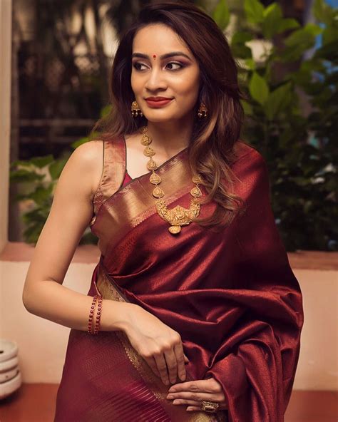 In A Gorgeous Maroon Color Saree And Sleeveless Blouse Design