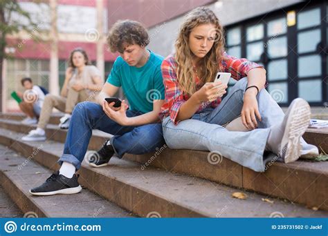 Teenagers With Smartphones Sitting On Stairs Stock Photo Image Of