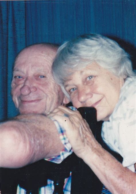 An Older Man And Woman Are Smiling For The Camera While Sitting Next To Each Other