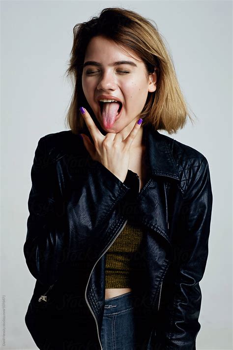 Teen Girl With Sign Of Horns Sticking Out Tongue By Danil Nevsky