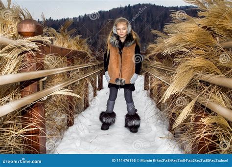 Cute Little Girl Is Standing On The Snow In The Snow Mountains Stock
