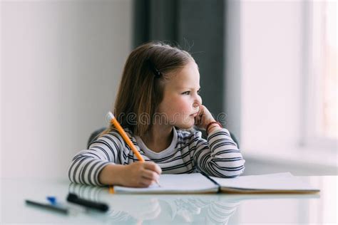 Little Cute Girl Is Bored And Tired With Doing Her Homework At Home