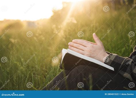Hombre Rezando En La Sagrada Biblia En Un Campo Durante La Puesta De
