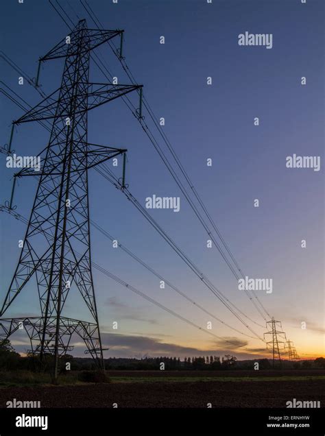 Row Of Electric Pylons In Fields At Sunset Stock Photo Alamy