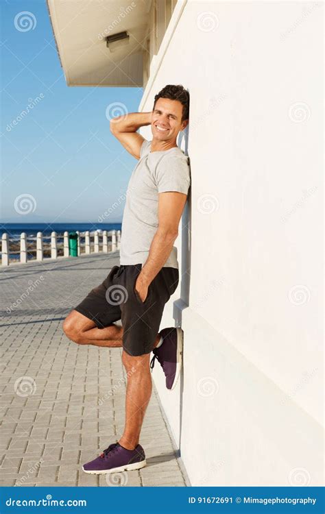 Side Portrait Of Fitness Man Leaning Against Wall Outside Stock Image