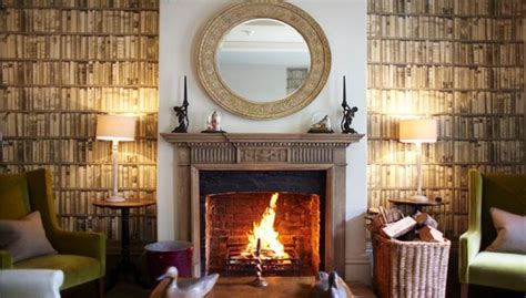 A diy fake fireplace made of ikea wall shelves and a few parts from the hardware store. Hotel Chic | Andrew Martin library wallpaper