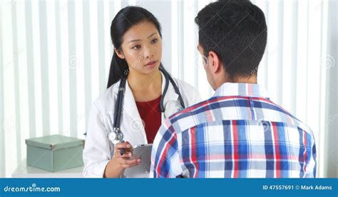 Asian Doctor Asking Patient Questions And Taking Notes Stock Image