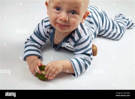 Retrato De Un Niño Pequeño Feliz Con Ropa A Rayas Comiendo Kiwi Sobre