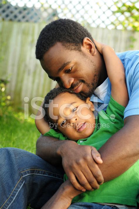 African American Father Lovingly Holding His Son Outside Stock Photo