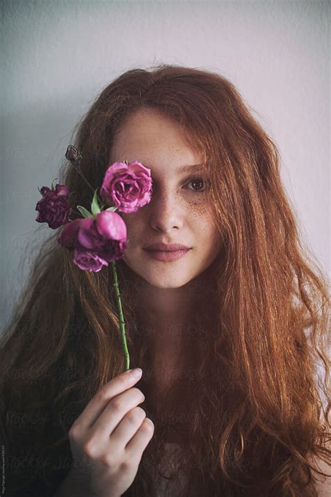 Portrait Of A Beautiful Redhead With Freckles Holding A Rose By Stocksy Contributor Maja