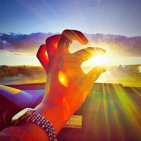 Premium Photo Optical Illusion Of Hand Holding Sun During Sunset