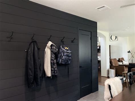There Is A Coat Rack On The Wall In This Living Room With Black Wood