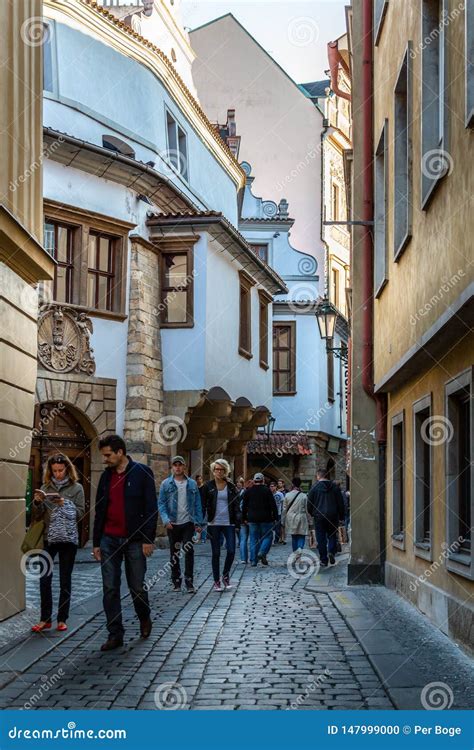 People Walking On A Narrow Cobblestone Street In The Old Town Of Prague