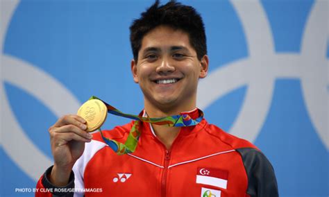 Joseph schooling poses with his gold medal after winning the men's 100m butterfly final. Joseph Schooling: The Singapore swimming star who beat idol Phelps